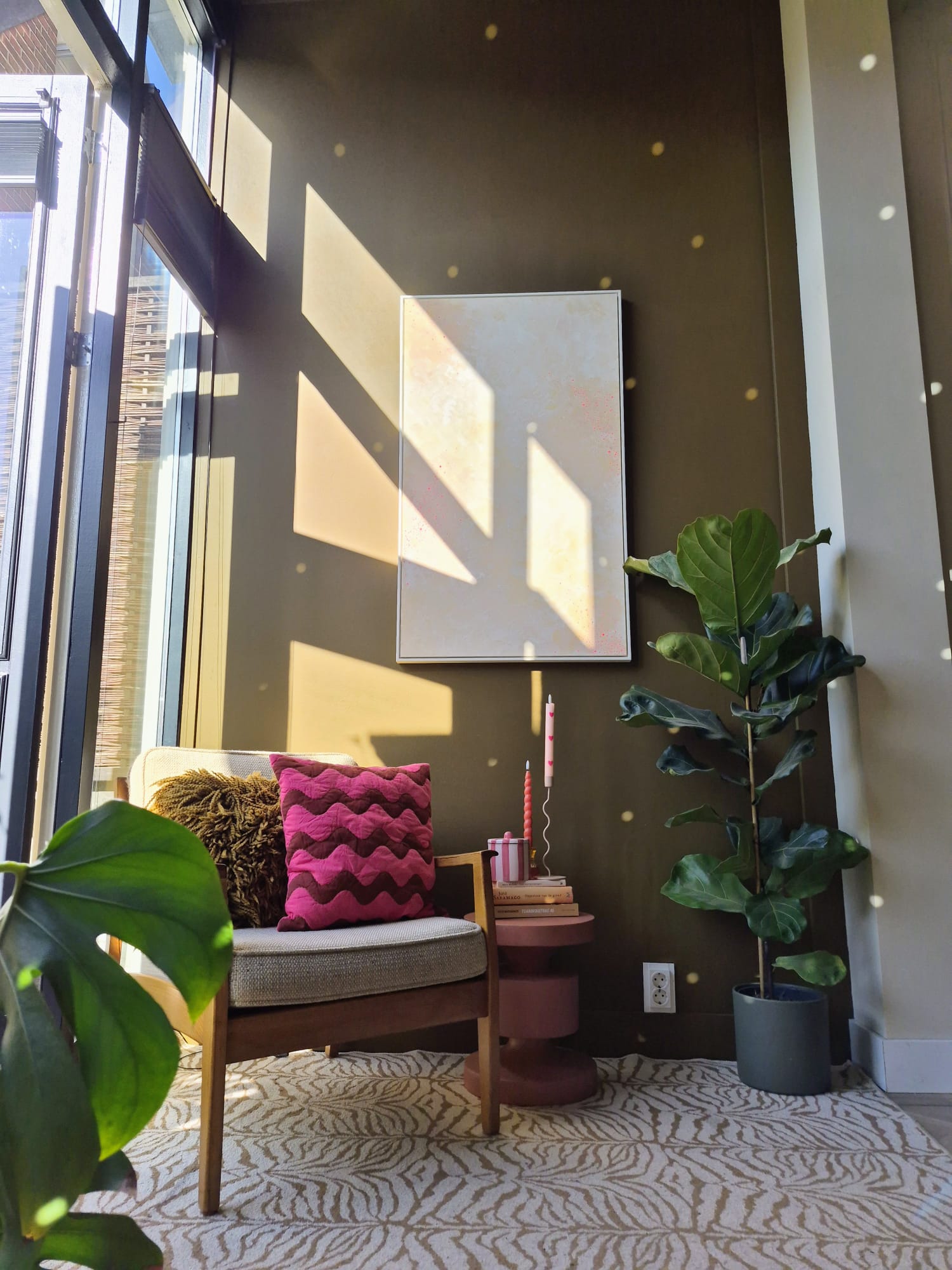 Leeshoek met fauteuil, roze kussen en vioolbladplant